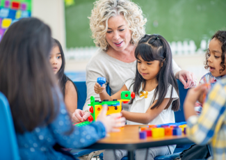 teacher assisting students at table