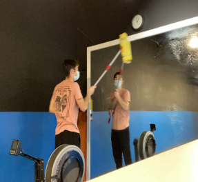 student cleaning mirror