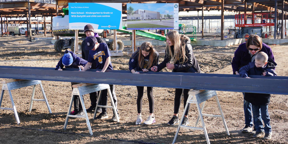 Students signing a beam for the new Kingsville K-12 school