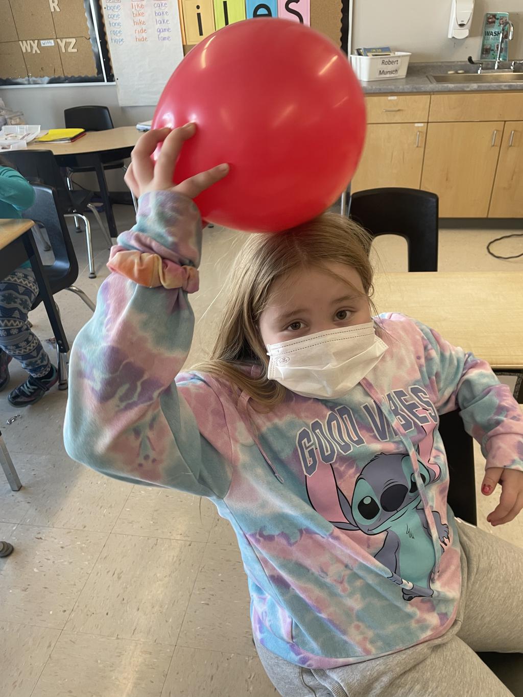 Student testing static electricity on her hair with a balloon