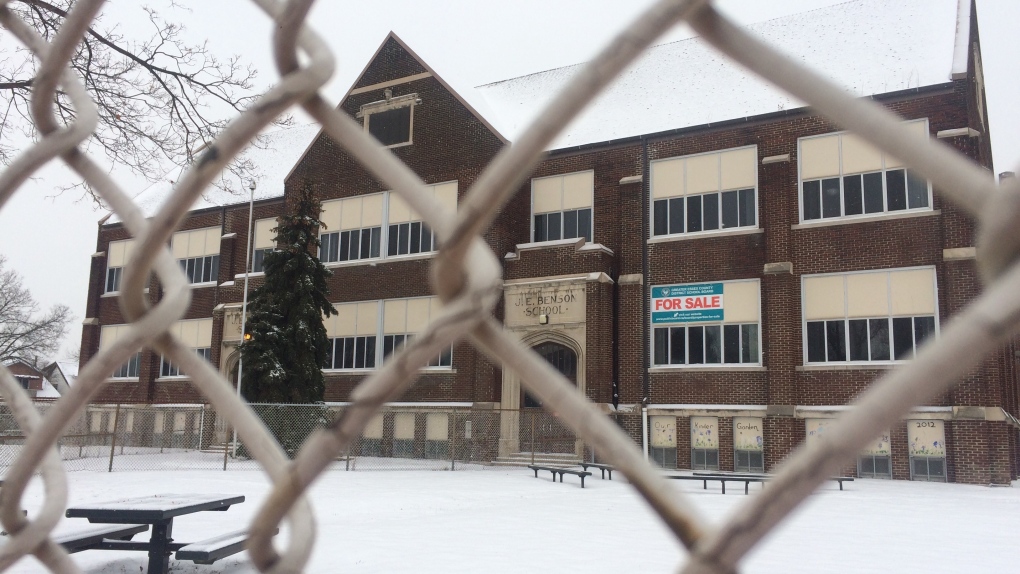 Old picture of Benson Public School through a chainlink fence